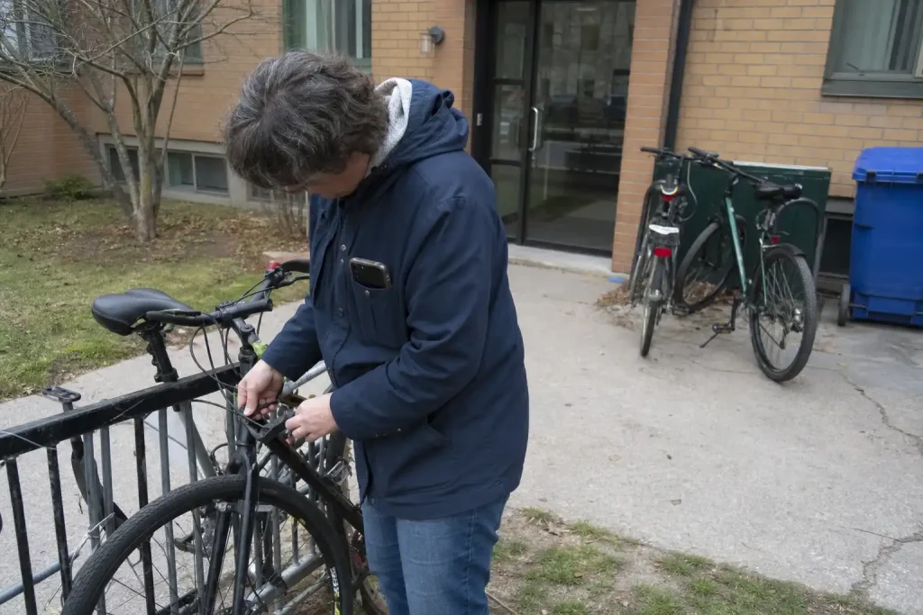En person låser upp sin cykel utomhus en molnig dag, på väg att svara på en larmutryckning. Medborgarförslag: Gör det lätt...